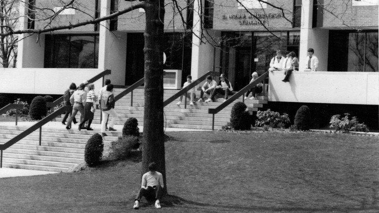 Students sitting outside of the library at Dean College.
