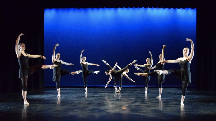 Eight dance students performing ballet during a performance onstage. 