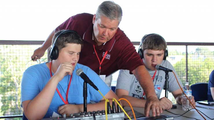 John Rooke, Director of The Center for Business, Entertainment and Sport Management, assists students with a broadcast at a minor league baseball game.
