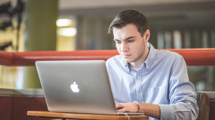 A student reviews his class notes while sitting in the Campus Center.