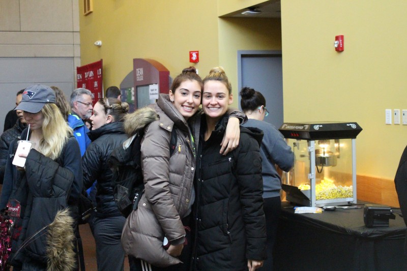 image of two students smiling and hugging in the dean college campus center to celebrate 50 days until commencement.