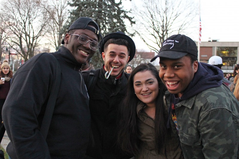 outdoor image of four students looking at the camera and smiling during an event for winter days.