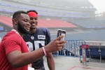 a student taking a photo with a new england patriots player at gillette stadium. 